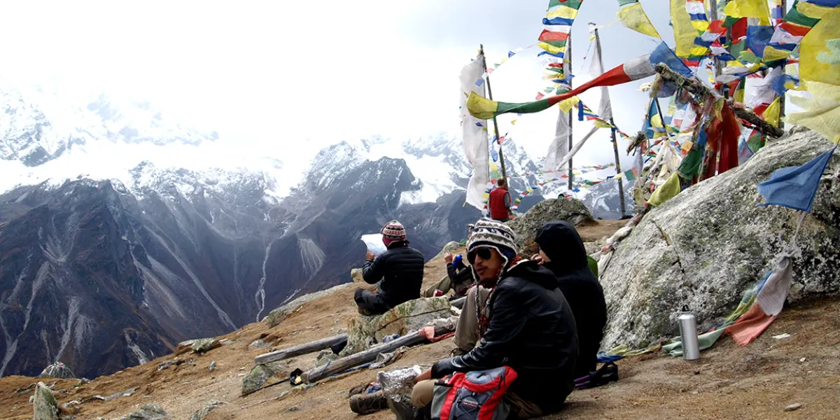 Consulting the map at a high-altitude pass, surrounded by flying prayer flags.
